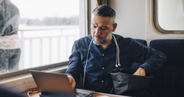 Confident male entrepreneur using laptop by window while traveling in ferry-344