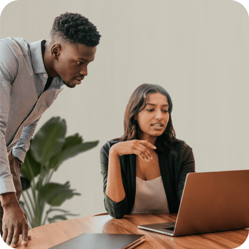 A man and a lady in discussion in front of a laptop