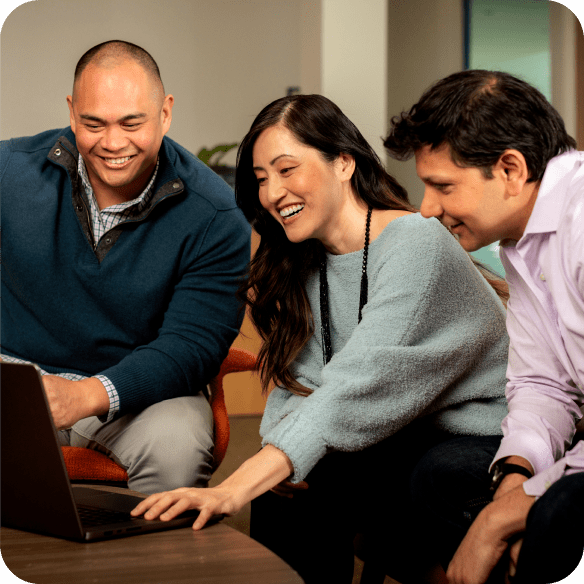 Colleagues collaborate in front of a laptop