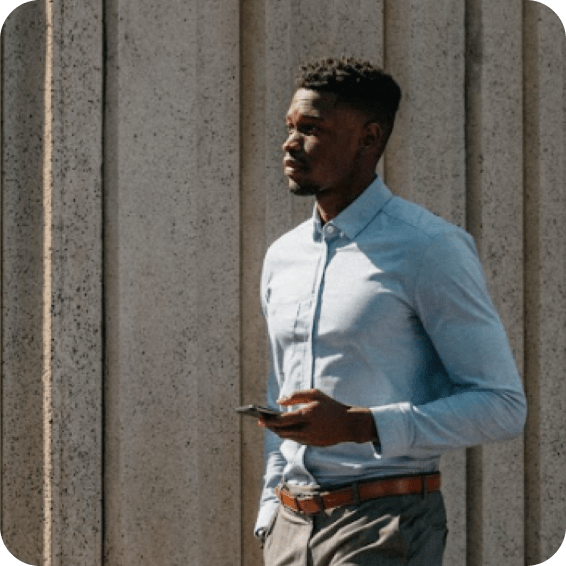 A man walking while holding his mobile phone